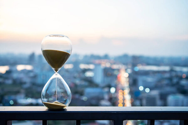 Hourglass in focus with buildings in background, Hourglass with cityscape on panoramic skyline and buildings in the morning background, The concept of modern life, time, management and city life.