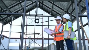 Genç mühendisler çalışıyor. Bir depo inşaatı planı. Deponun inşaat çizimlerine bak..