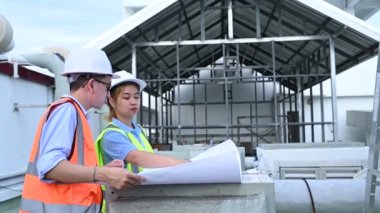 Genç mühendisler çalışıyor. Bir depo inşaatı planı. Deponun inşaat çizimlerine bak..