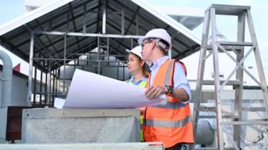 Genç mühendisler çalışıyor. Bir depo inşaatı planı. Deponun inşaat çizimlerine bak..