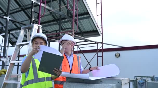 年轻的工程师在工作建造一个仓库的计划 参见存储设施的施工图纸 — 图库视频影像