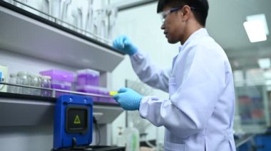 Laboratuvarda çalışan Asyalı bilim adamı, ürün deneyi yaparken, araştırmacılar deneyin sonuçlarını bulmak için analiz ettiler. Değerleri işlemek için bilimsel araçlar kullan.