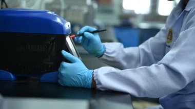 Laboratuvarda çalışan Asyalı bilim adamı, ürün deneyi yaparken, araştırmacılar deneyin sonuçlarını bulmak için analiz ettiler. Değerleri işlemek için bilimsel araçlar kullan.