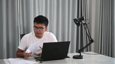 Asyalı işadamı tatilde evde çalışıyor. Ev kavramından çalış. Evde yapmak için iş getir.