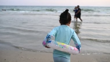 Asyalı kız eğlencesine denizde oynuyor. Aileyle yaz tatili. Çocuk sömestr tatili aktiviteleri
