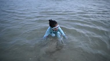 Asyalı kız eğlencesine denizde oynuyor. Aileyle yaz tatili. Çocuk sömestr tatili aktiviteleri