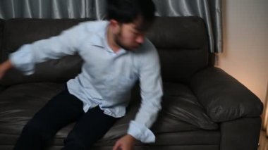 Asyalı yakışıklı adam aşırı iş yükünden dolayı stresli. Yorgun erkek, şirketten bir sürü iş ve depresyon riskinden sonra eve döner.