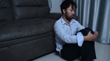 Asyalı yakışıklı adam aşırı iş yükünden dolayı stresli. Yorgun erkek, şirketten bir sürü iş ve depresyon riskinden sonra eve döner.