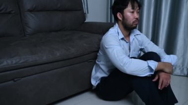 Asyalı yakışıklı adam aşırı iş yükünden dolayı stresli. Yorgun erkek, şirketten bir sürü iş ve depresyon riskinden sonra eve döner.