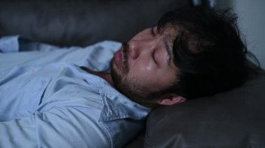 Asyalı yakışıklı adam aşırı iş yükünden dolayı stresli. Yorgun erkek, şirketten bir sürü iş ve depresyon riskinden sonra eve döner.