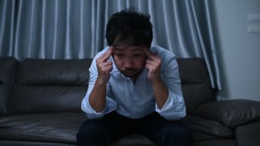 Asyalı yakışıklı adam aşırı iş yükünden dolayı stresli. Yorgun erkek, şirketten bir sürü iş ve depresyon riskinden sonra eve döner.