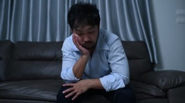 Asyalı yakışıklı adam aşırı iş yükünden dolayı stresli. Yorgun erkek, şirketten bir sürü iş ve depresyon riskinden sonra eve döner.