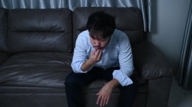 Asyalı yakışıklı adam aşırı iş yükünden dolayı stresli. Yorgun erkek, şirketten bir sürü iş ve depresyon riskinden sonra eve döner.