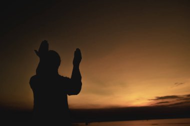 Siluet Genç Asyalı Müslüman adam gün batımında dua ediyor, Ramazan festivali konsepti