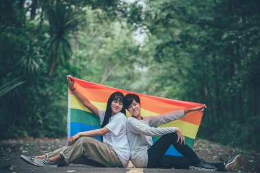 Kızlı bir çift, LGBT Onur Ayı konsepti, Asyalı yakışıklı erkek makyaj ve kadın kıyafeti, Gay Özgürlük Günü, beyaz arka planda ikili olmayan portre