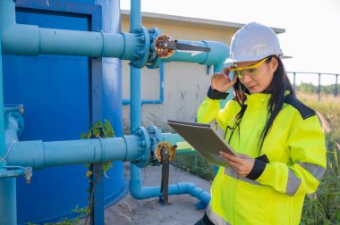 Çevre mühendisleri atık su arıtma tesislerinde çalışıyor. Su ikmali yapan kadın tesisatçı teknisyen.