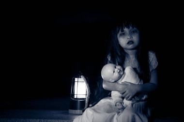 Gece üzgün çocuk hayaleti, Cadılar Bayramı festivali konsepti, 13. Cuma, korku filmi sahnesi, oyuncak bebeği olan bir kız.