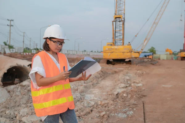 Civil engineers working at a construction site,The company manager supervises the road construction.