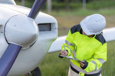 Teknisyen uçağın motorunu tamir ediyor, kadın uzay mühendisliği uçak motorlarını kontrol ediyor, Asyalı tamirci uçak motorlarını kontrol ediyor.