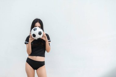 Genç ve güzel Asyalı kadın futbolcu amigo sporu giyer, bayan taraftarlar futbol takımına tezahürat yapar.