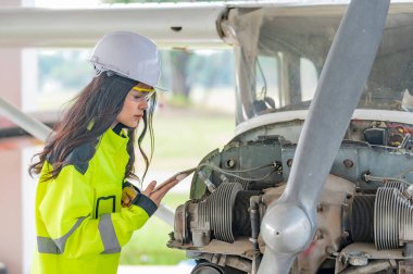 Teknisyen uçağın motorunu tamir ediyor, kadın uzay mühendisliği uçak motorlarını kontrol ediyor, Asyalı tamirci uçak motorlarını kontrol ediyor.