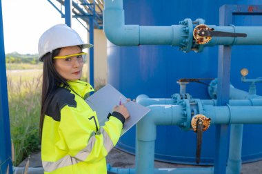 Çevre mühendisleri atık su arıtma tesislerinde çalışıyor. Su ikmali yapan kadın tesisatçı teknisyen.