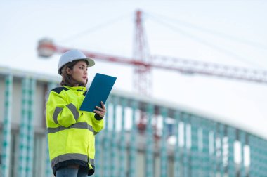 Tayland 'da büyük bir inşaat projesinin şantiyesinde çalışan Asyalı mühendis inşaat alanında fazla mesai yapıyor.