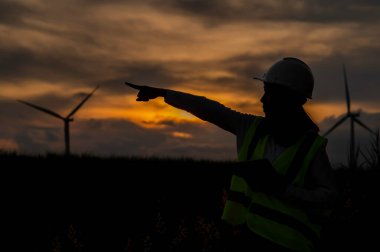 Kadın mühendis, Tayland 'daki dağda rüzgar türbini tarım güç jeneratörü istasyonunda çalışıyor ve raporu tutuyor.