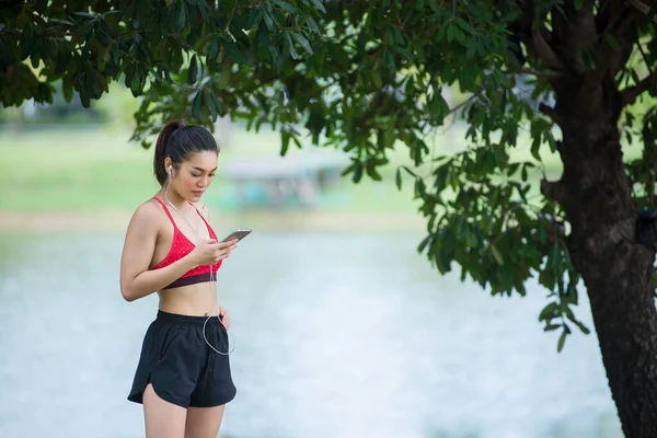 Asian beautiful woman wear running suit at the park,Lifestyle of modern woman,Choose a song to listen to while running.