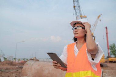 Civil engineers working at a construction site,The company manager supervises the road construction.
