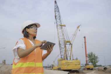 Civil engineers working at a construction site,The company manager supervises the road construction.