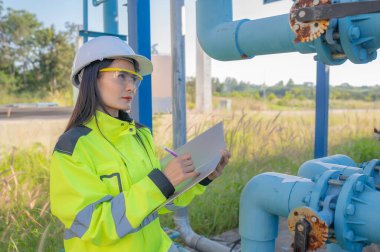 Çevre mühendisleri atık su arıtma tesislerinde çalışıyor. Su ikmali yapan kadın tesisatçı teknisyen.