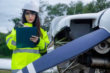 Teknisyen uçağın motorunu tamir ediyor, kadın uzay mühendisliği uçak motorlarını kontrol ediyor, Asyalı tamirci uçak motorlarını kontrol ediyor.