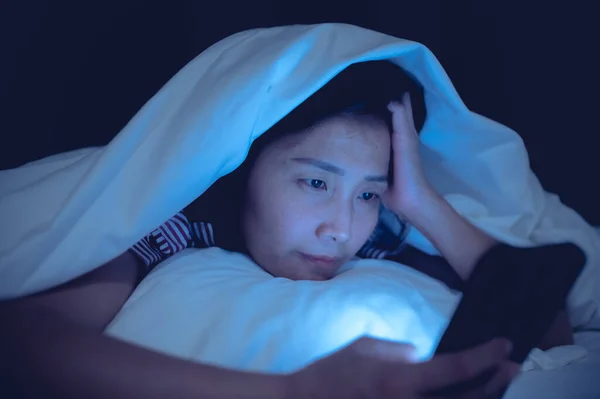 Asian woman playing game on smartphone in the bed at night,Thailand people,Addict social media