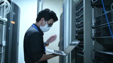 Computer engineer is setting up network in server room. Systems Maintenance Technician