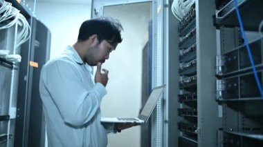 Computer engineer is setting up network in server room. Systems Maintenance Technician