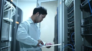 Computer engineer is setting up network in server room. Systems Maintenance Technician