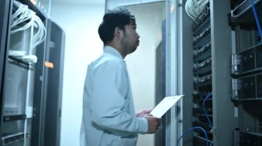 Computer engineer is setting up network in server room. Systems Maintenance Technician