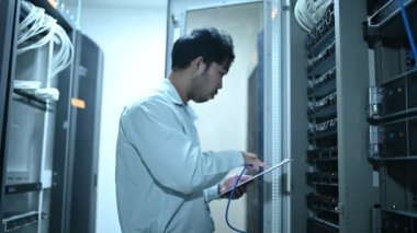 Computer engineer is setting up network in server room. Systems Maintenance Technician