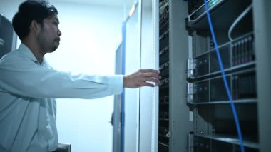 Computer engineer is setting up network in server room. Systems Maintenance Technician