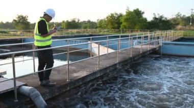 Çevre mühendisi atık su arıtma tesislerinde çalışıyor. Su geri dönüşüm tesisinde tekrar kullanılmak üzere çalışan su tedarik mühendisliği 