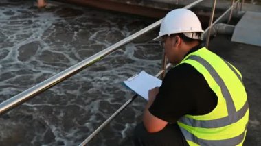 Çevre mühendisi atık su arıtma tesislerinde çalışıyor. Su geri dönüşüm tesisinde tekrar kullanılmak üzere çalışan su tedarik mühendisliği 