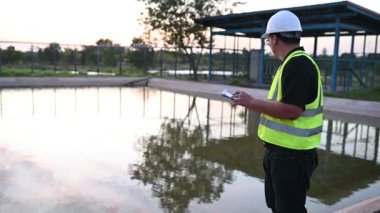 Çevre mühendisi atık su arıtma tesislerinde çalışıyor. Su geri dönüşüm tesisinde tekrar kullanılmak üzere çalışan su tedarik mühendisliği 