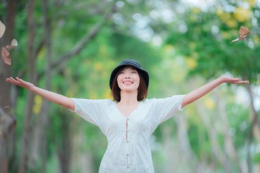 Güzel Asyalı bir kadının portresi açık havada beyaz elbiseler giyiyor, modern bir kadının yaşam tarzı.