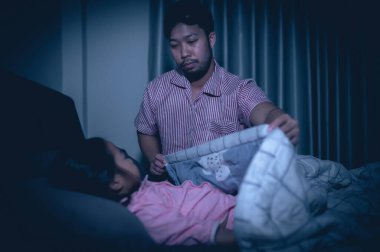 Baba ve kızı yatak odasında uyur, telefonlu çizgi film izler, Babalar Günü konsepti, bekar baba, uyumadan önce masal dinler.