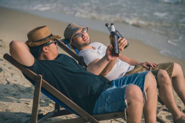 İki adam sahilde bira içer, yaz mevsiminde denizde arkadaşlarıyla vakit geçirir, biraz dinlenir, gay aşklarını paylaşır.