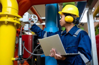 Bir ısıtma tesisinde bakım teknisyeni, Petrokimya işçileri fabrikadaki gaz ve petrol boru hatlarının işleyişini denetliyor, mühendisler işitme koruyucularını birçok boruyla aynı odaya koyuyorlar.