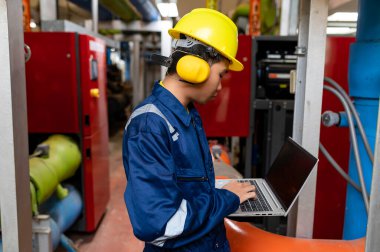 Bir ısıtma tesisinde bakım teknisyeni, Petrokimya işçileri fabrikadaki gaz ve petrol boru hatlarının işleyişini denetliyor, mühendisler işitme koruyucularını birçok boruyla aynı odaya koyuyorlar.