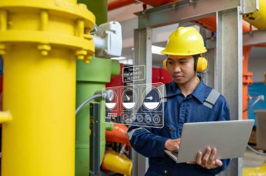 Bir ısıtma tesisinde bakım teknisyeni, Petrokimya işçileri fabrikadaki gaz ve petrol boru hatlarının işleyişini denetliyor, mühendisler işitme koruyucularını birçok boruyla aynı odaya koyuyorlar.