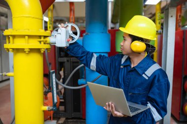 Bir ısıtma tesisinde bakım teknisyeni, Petrokimya işçileri fabrikadaki gaz ve petrol boru hatlarının işleyişini denetliyor, mühendisler işitme koruyucularını birçok boruyla aynı odaya koyuyorlar.